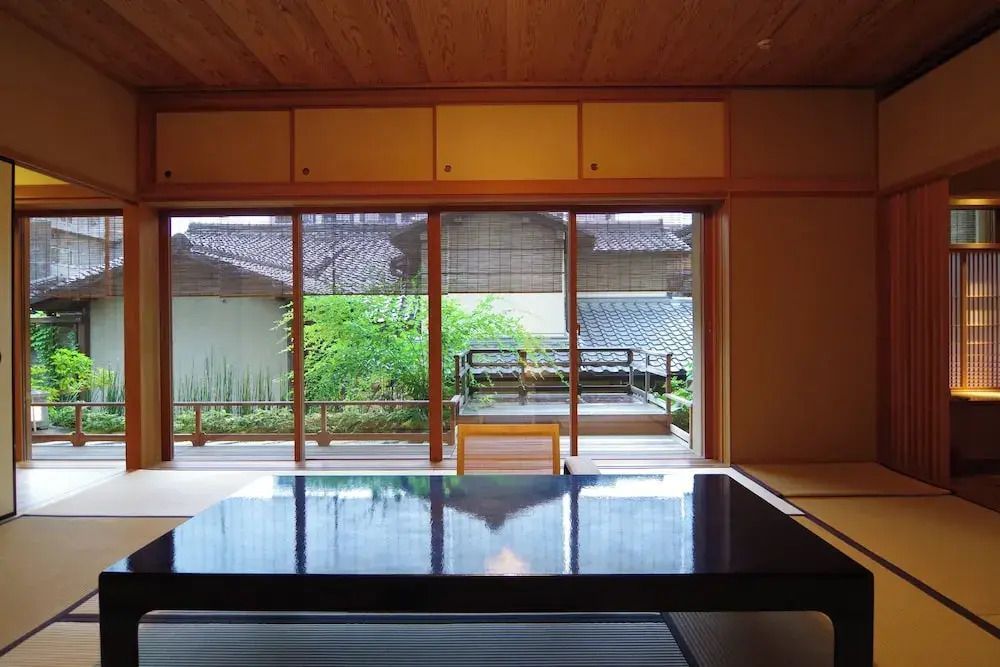 Geräumiges Zimmer mit Blick in den Garten durch große Fenster.