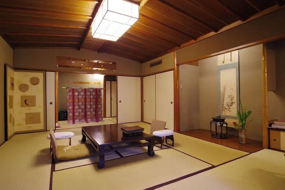 Raum mit Tatami, Holzelementen und traditioneller Dekoration.