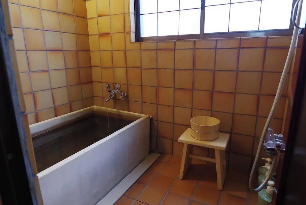 Traditionelles japanisches Badezimmer im Hiiragiya Ryokan mit Holzbadewanne.