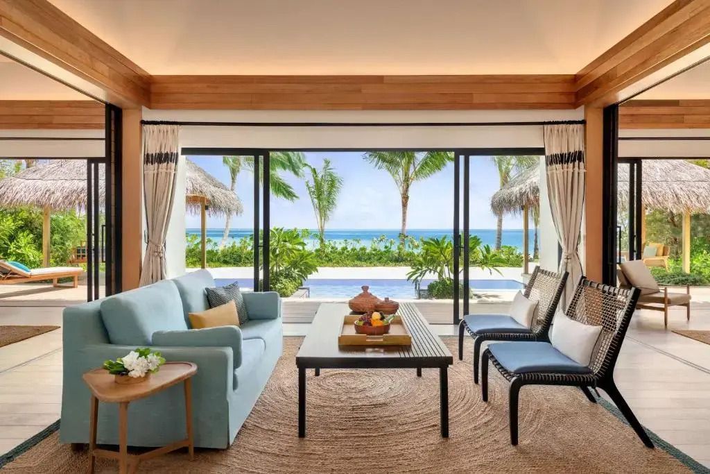 Wohnbereich mit Meerblick und eleganten Möbeln im Hilton Maldives Amingiri Resort.