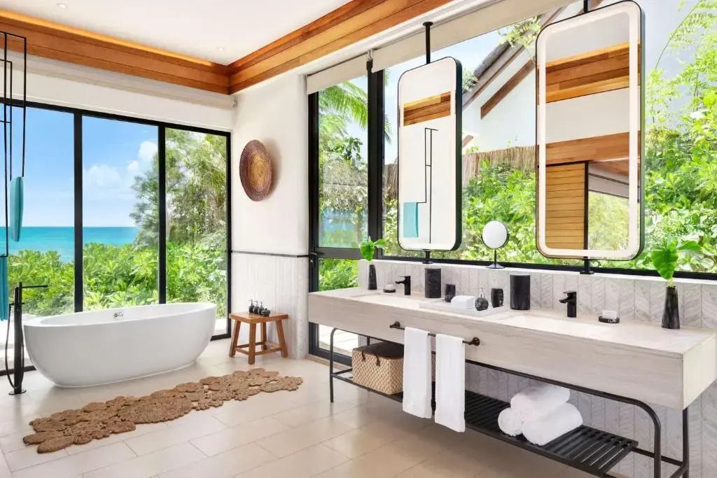 Modernes Badezimmer mit Badewanne und großem Fenster im Hilton Maldives Amingiri Resort.