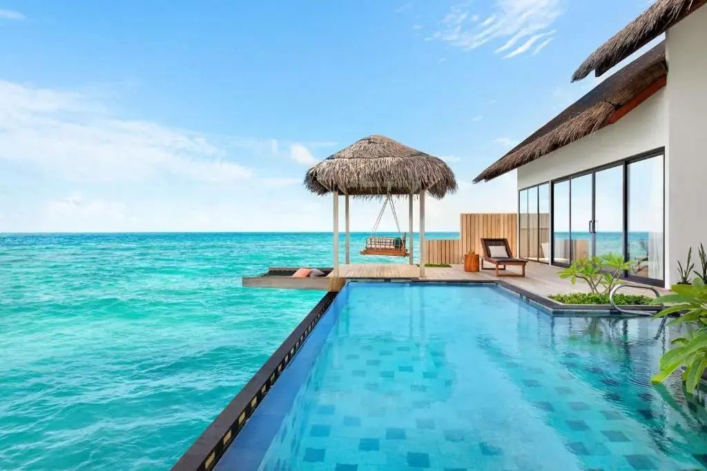 Privater Pool mit Meerblick und Liegeflächen im Hilton Maldives Amingiri Resort.