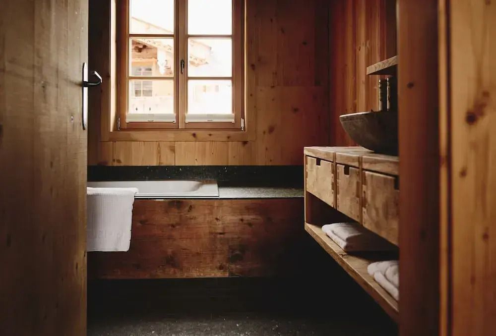 Holzverkleidetes Badezimmer mit Fenster und moderner Ausstattung