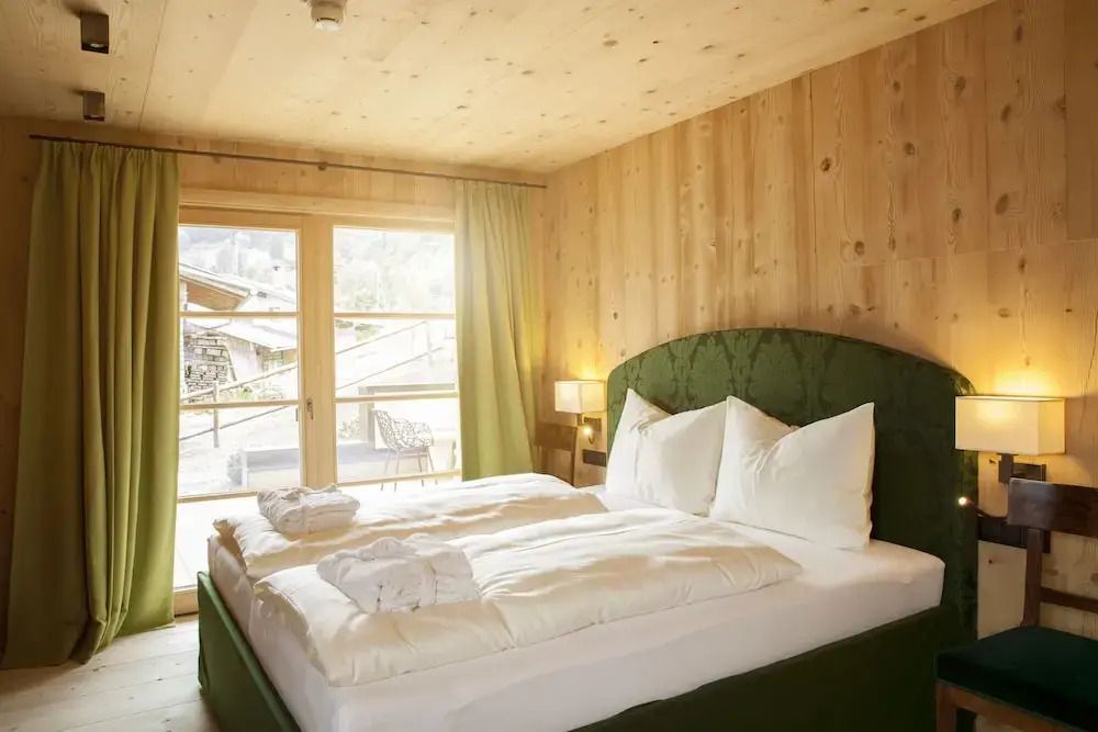 Helles Schlafzimmer mit Doppelbett und großen Fenstern