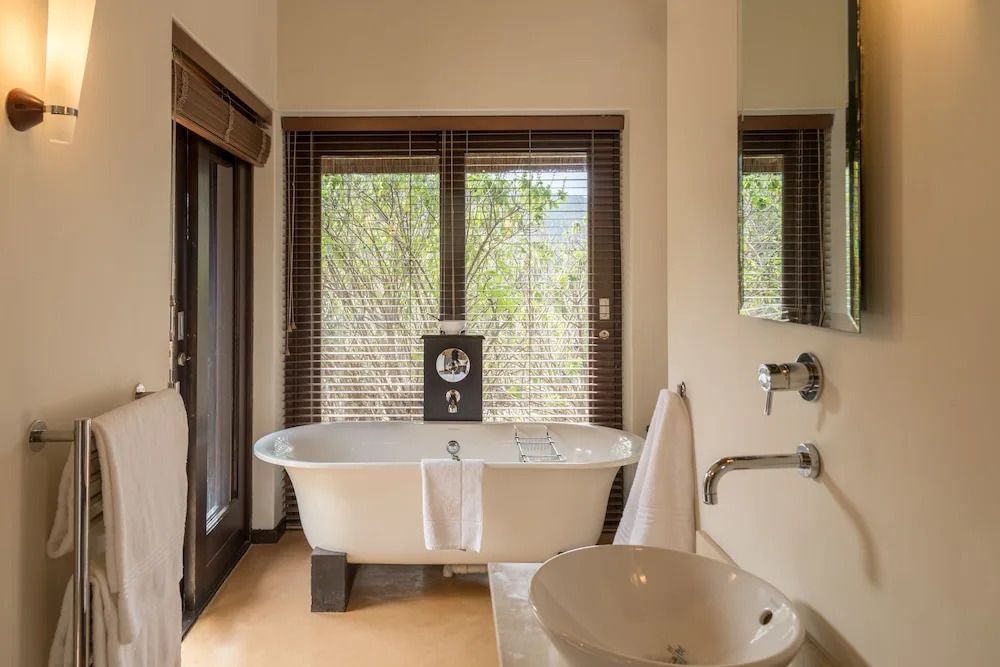 Luxuriöses Badezimmer mit freistehender Badewanne und Ausblick