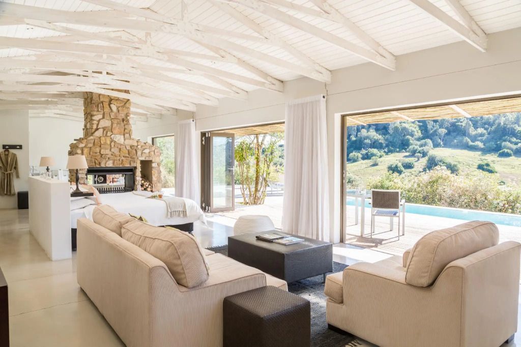Helle Suite mit offenem Kamin und Blick auf Pool im Hopewell Private Game Reserve
