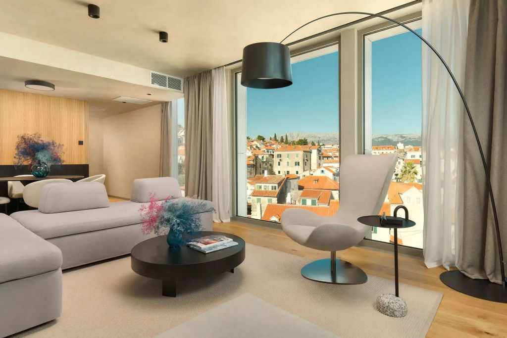 Helles Wohnzimmer mit Designer-Sessel und Blick über Split
