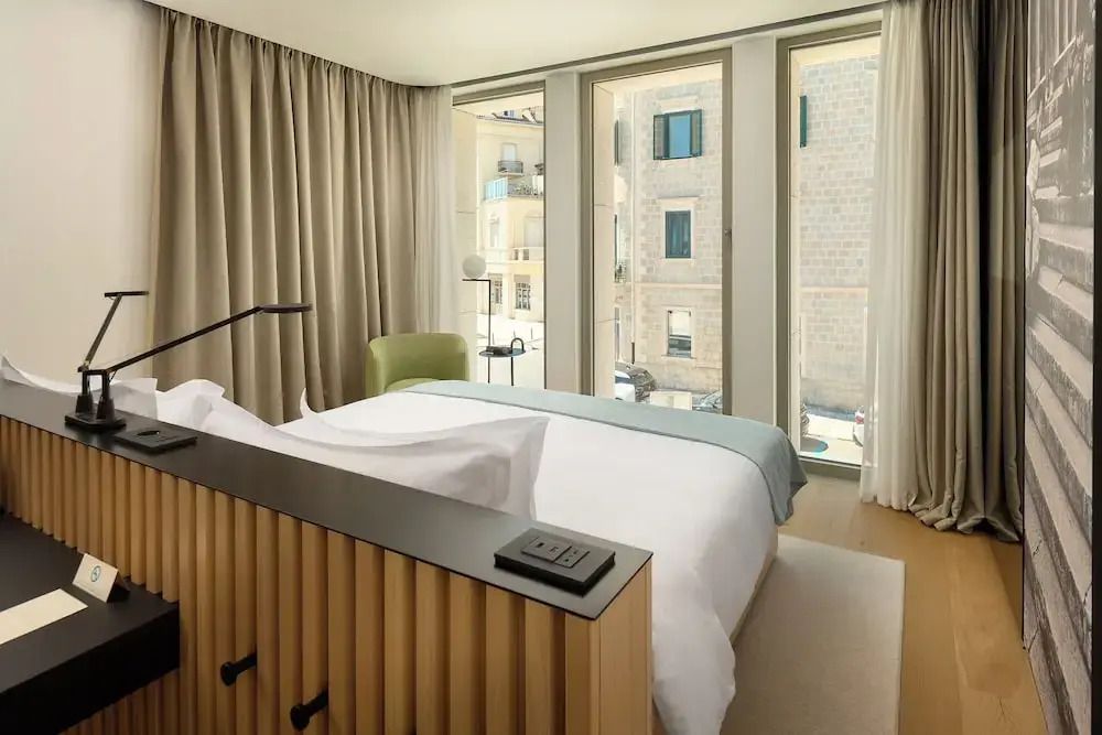 Doppelzimmer mit großem Fenster und Blick auf die Straße, eleganter und moderner Stil.
