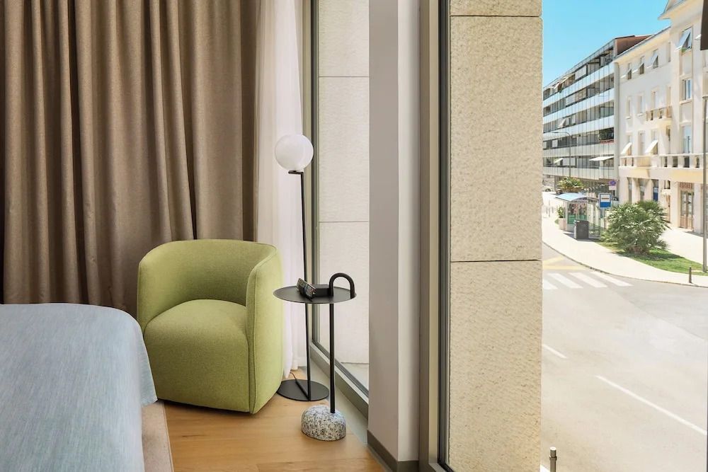 Gemütlicher Sitzbereich im Hotelzimmer mit modernem Design und Straßenausblick.