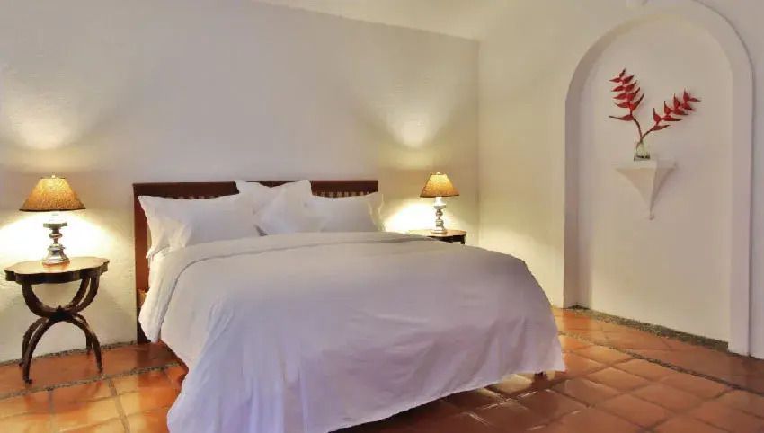 Gemütliches Deluxe Doppelzimmer mit großem Doppelbett und eleganter Nachttischlampe
