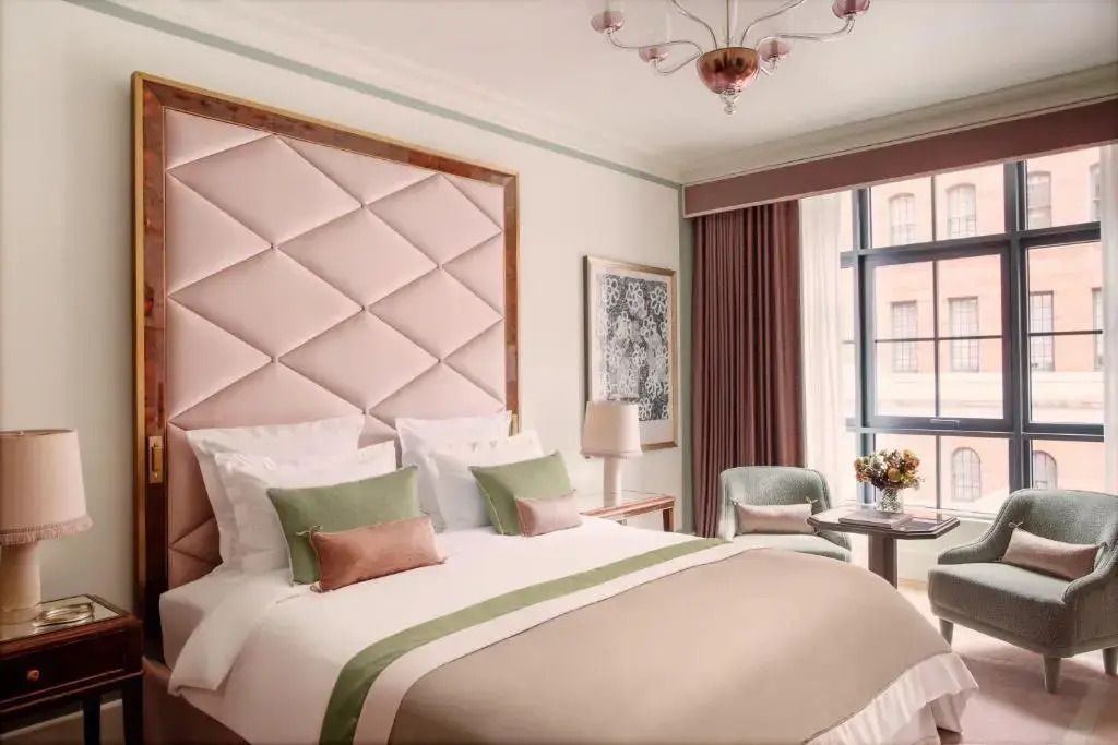 Deluxe Doppelzimmer mit gepolsterter Kopfleiste, eleganter Beleuchtung und großen Fenstern