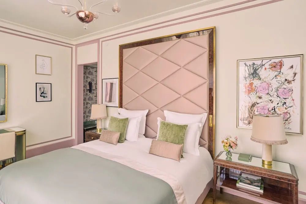 Gemütliches Doppelbett in einem klassisch eingerichteten Hotelzimmer mit weichen Kissen.