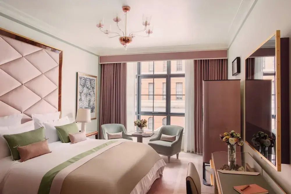 Elegantes Prestige Doppelzimmer mit einem großen Bett, Fenster und stilvollen Möbeln