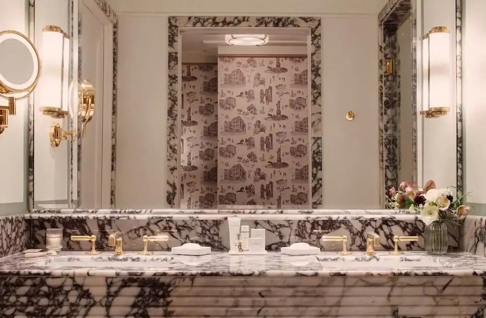 Luxuriöses Badezimmer mit Marmordekor und großen Spiegeln