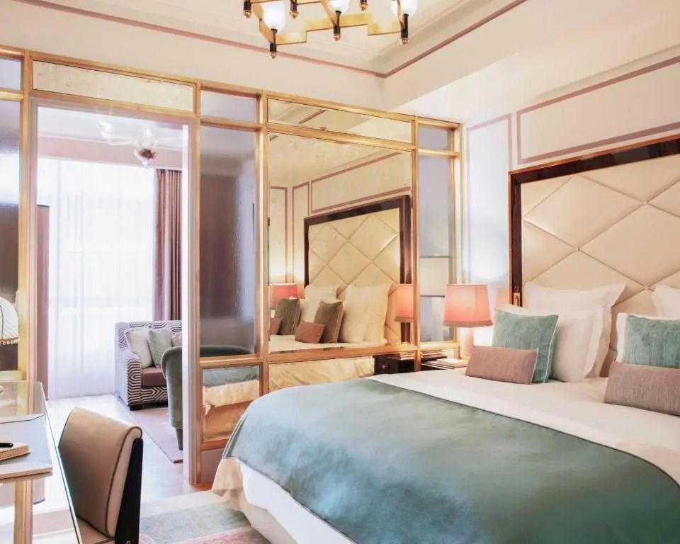 Luxuriöse Prestige Junior-Suite mit großem Bett und eleganten Möbeln.