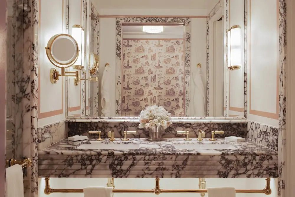 Marmorbadezimmer mit Doppelwaschtisch und goldenen Armaturen
