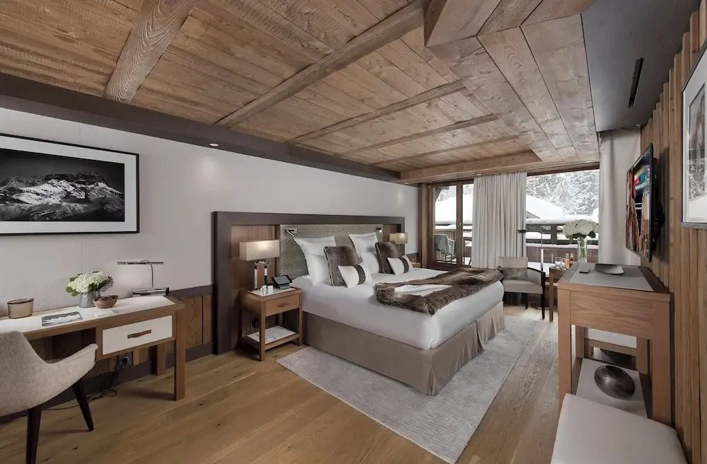 Geräumiges Schlafzimmer mit Holzdecke und Ausblick auf die Natur.