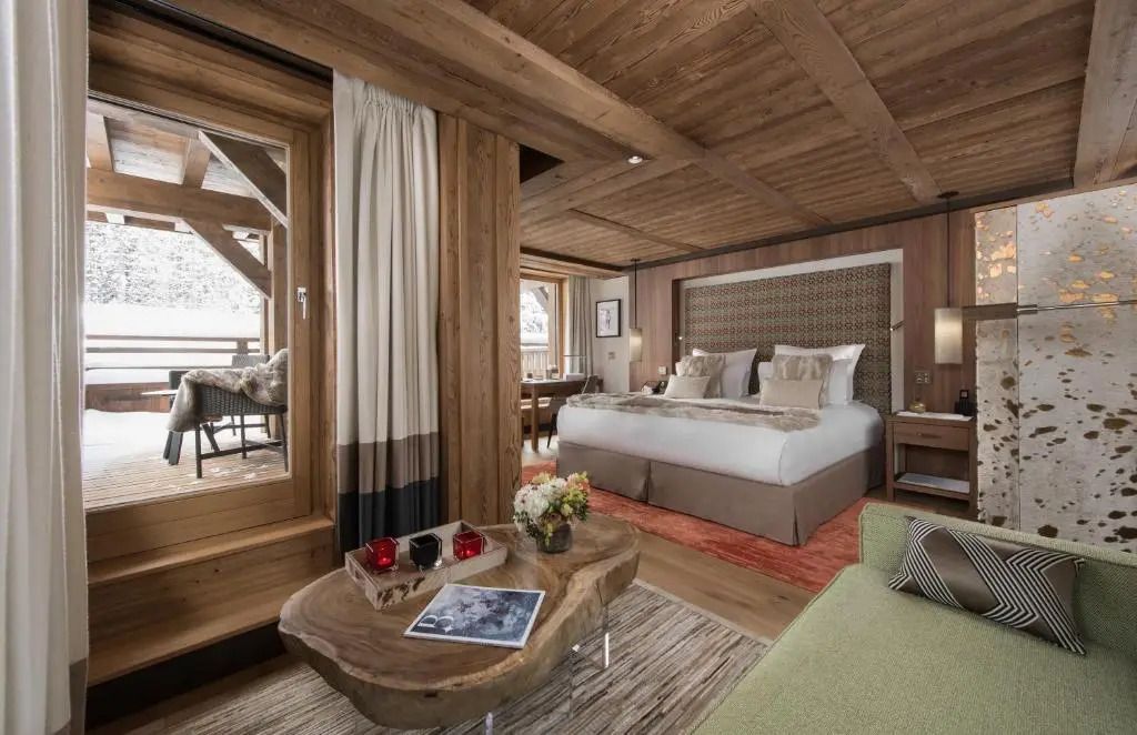 Gemütliches Schlafzimmer in einer Junior-Suite mit Holzelementen und Balkonblick
