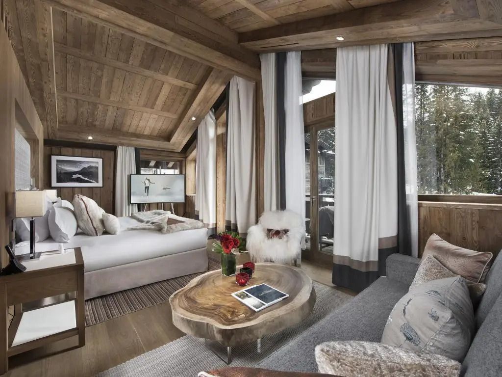 Gemütlicher Wohnbereich der Prestige Junior-Suite mit Holzmöbeln und großen Fenstern.