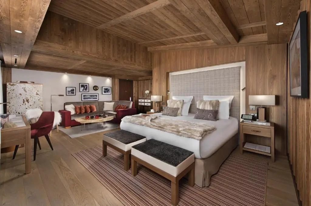 Prestige Junior-Suite mit großem Bett und warmen Holzelementen.