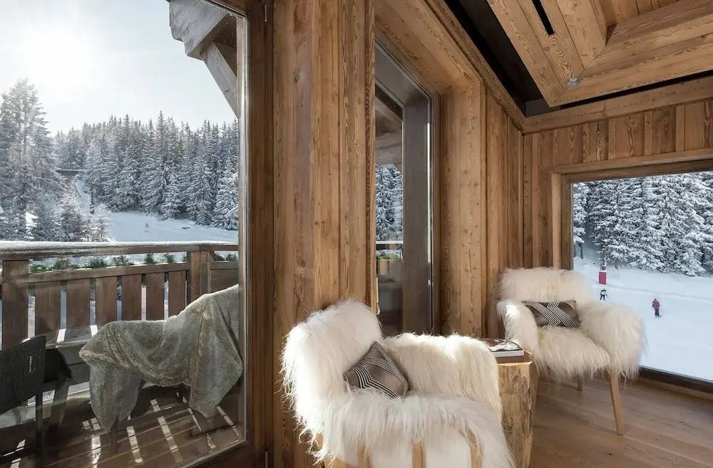 Gemütliche Sitzecke mit Blick auf verschneite Landschaft in Courchevel.