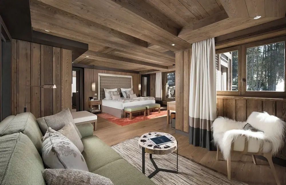 Geräumige Suite mit gemütlicher Sitzecke und Holzvertäfelung in Courchevel.