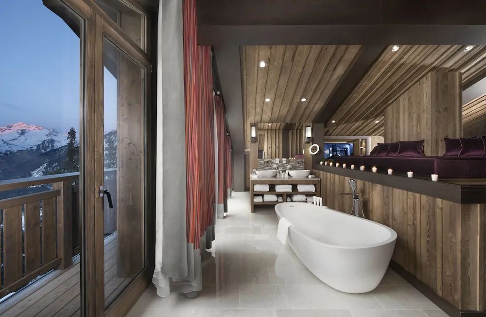 Luxuriöses Badezimmer mit freistehender Badewanne und moderner Holzdecke