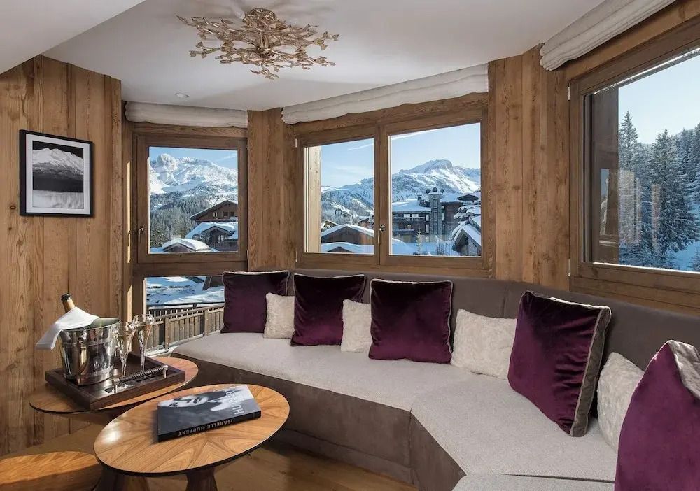 Gemütliche Sitzecke mit Panoramablick auf schneebedeckte Berge in der Suite.