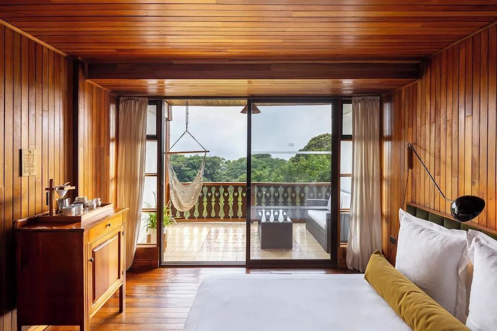 Zimmer mit großem Balkon und Hängesessel Aussicht auf Wald