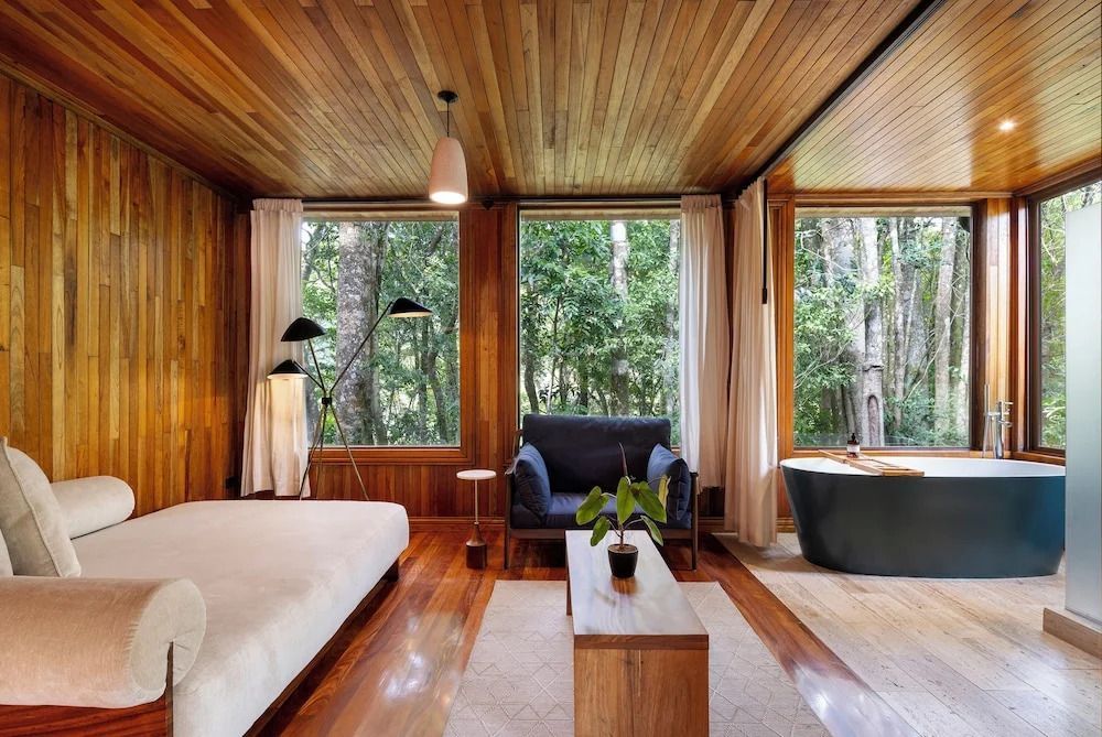 Modernes Studio mit Holzausstattung und großer Fensterfront mit Waldblick