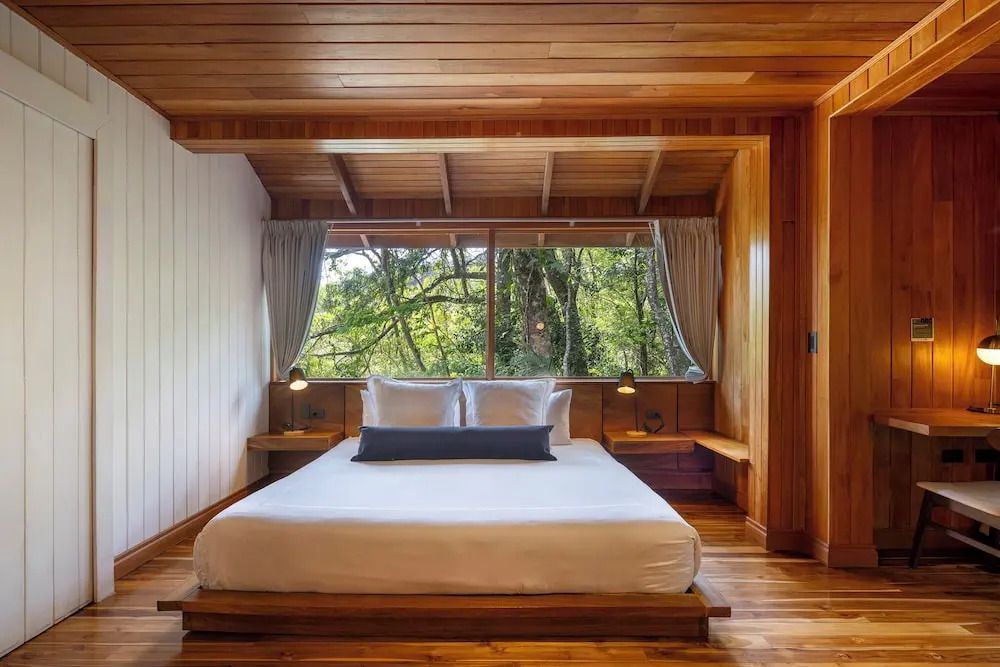 Gemütliches Schlafzimmer mit Holzwänden und großem Bett im Studio