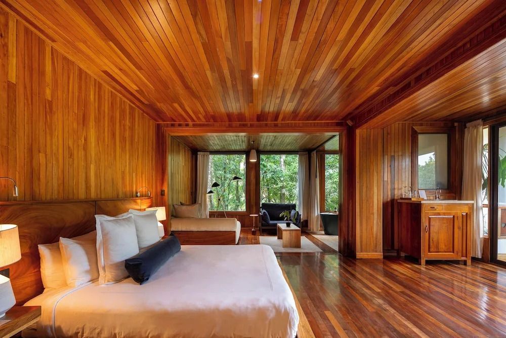 Großes Studio mit Holzdecke, luxuriösem Bett und Sitzbereich