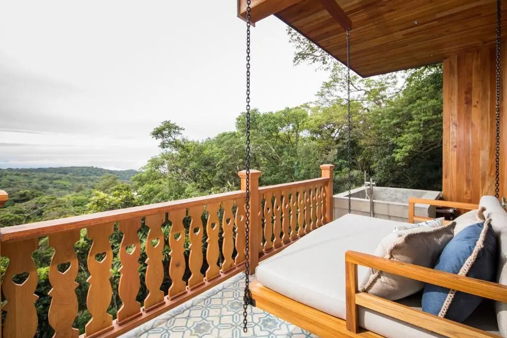 Hängesessel auf einem Holzbalkon mit Blick auf die Natur