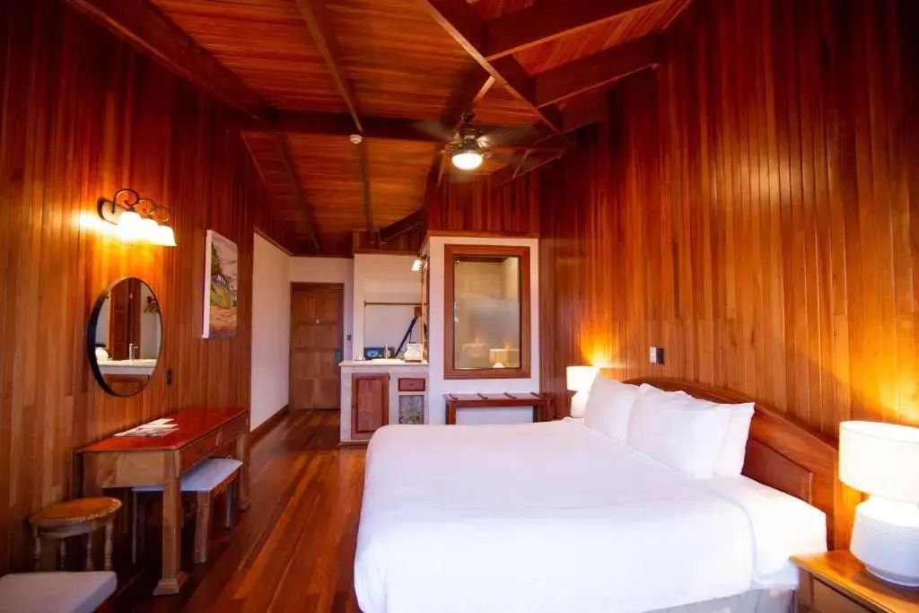 Superior Zimmer mit Holzwänden, großem Bett und kleinem Tisch