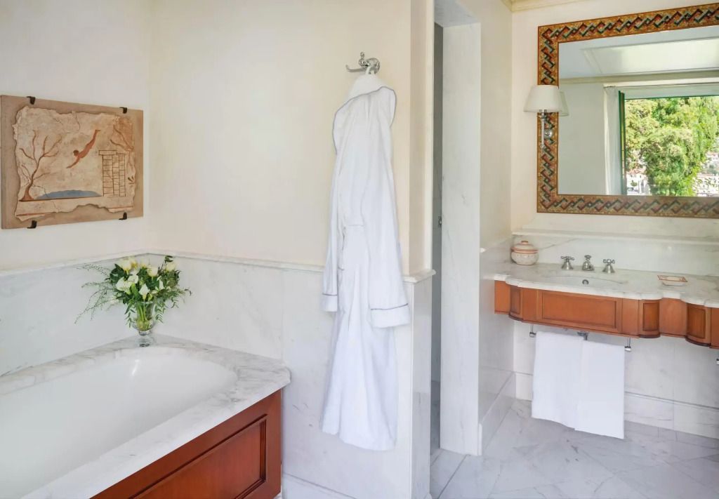 Luxuriöses Badezimmer mit Marmorbadewanne und Bademantel im Caruso Hotel