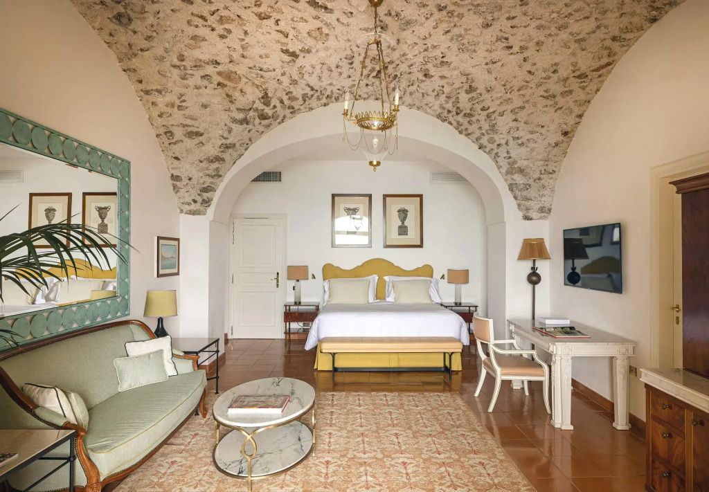 Luxuriöses Doppelzimmer mit gewölbter Decke, elegantem Dekor und komfortablem Doppelbett.