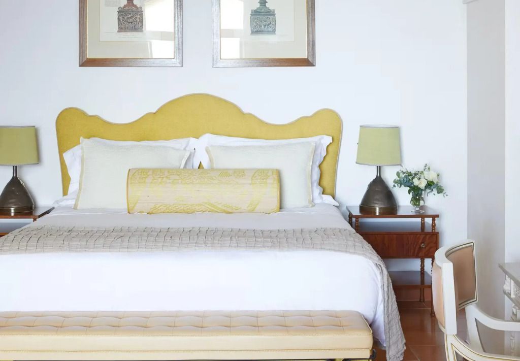 Gemütliches Doppelbett mit stilvollem Kopfteil und modernen Nachttischen im Deluxe-Zimmer.