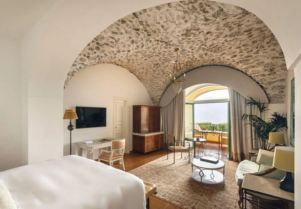 Geräumiges Zimmer mit Balkon-Meerblick, eleganter Einrichtung und Gewölbedecke.