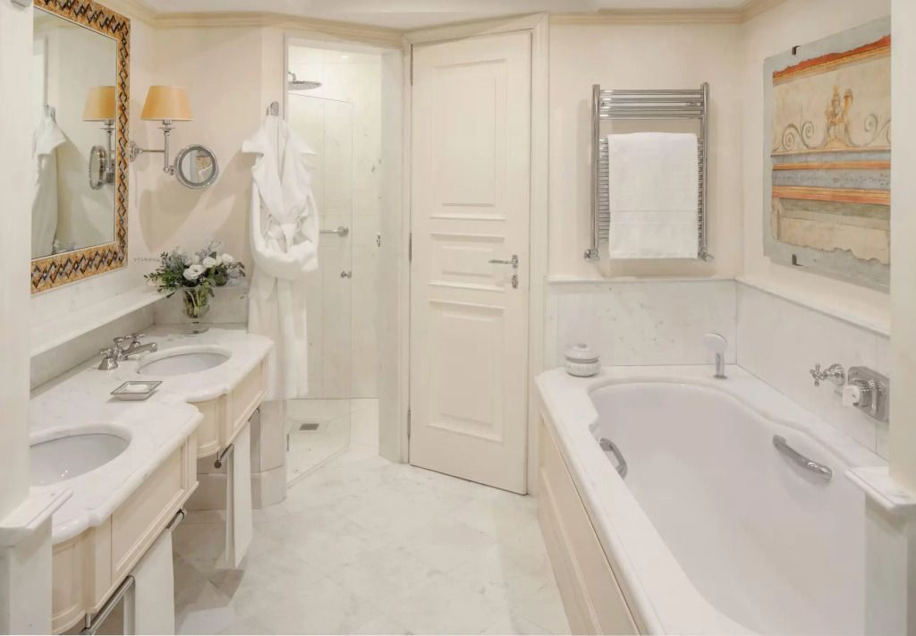 Luxuriöses Badezimmer mit Badewanne und Doppelwaschbecken in weichen Tönen.
