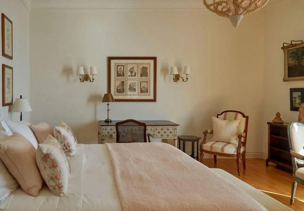 Stilvolles Schlafzimmer mit dekorativem Wandbild und gemütlicher Sitzgelegenheit