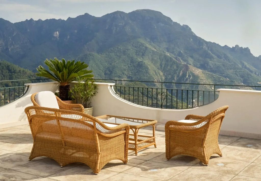 Terrasse mit Korbmöbeln und beeindruckendem Bergblick
