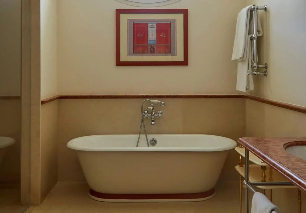 Bad mit freistehender Badewanne und dekorativem Kunstwerk an der Wand