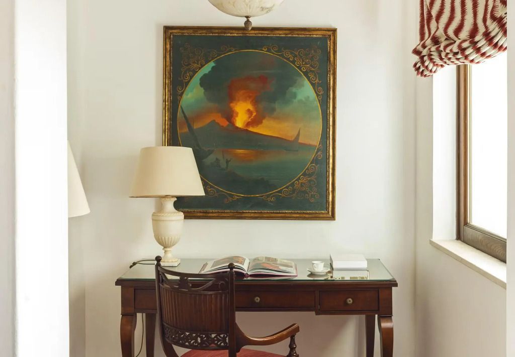 Eleganter Schreibtisch mit antikem Gemälde im Hintergrund in der Suite