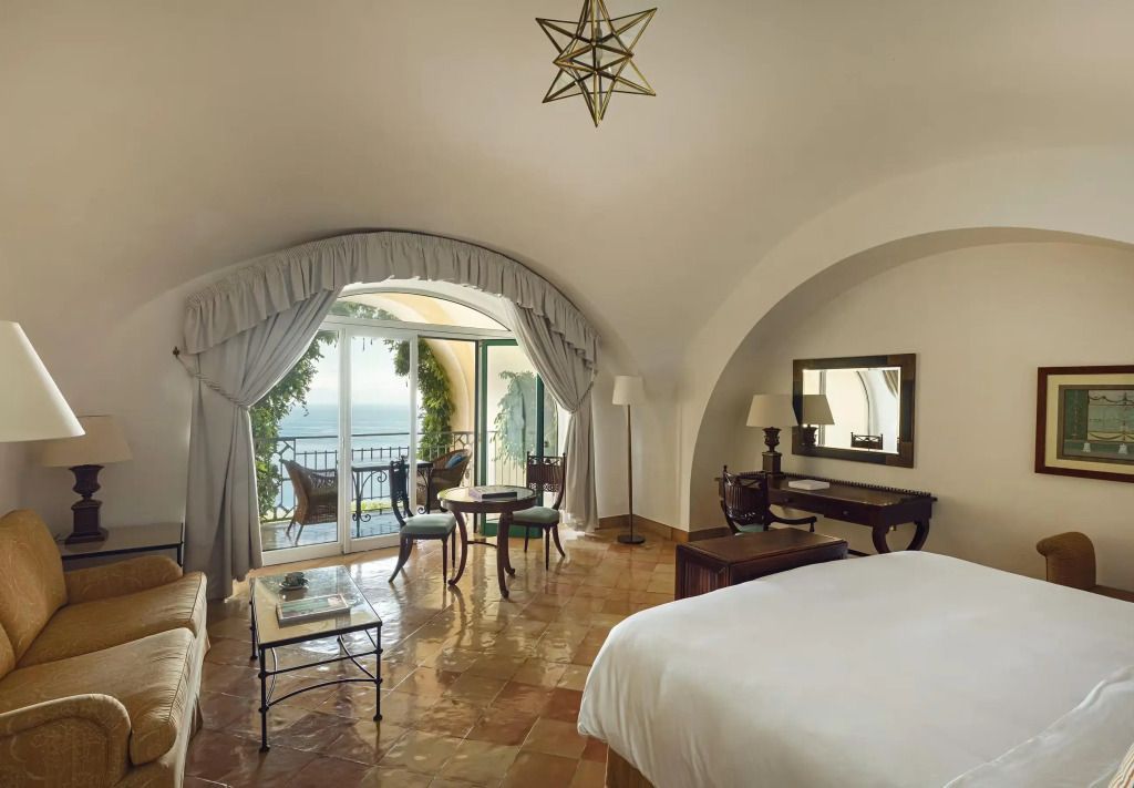 Geräumige Suite mit Meerblick und gemütlicher Sitzgelegenheit auf der Amalfi Coast.