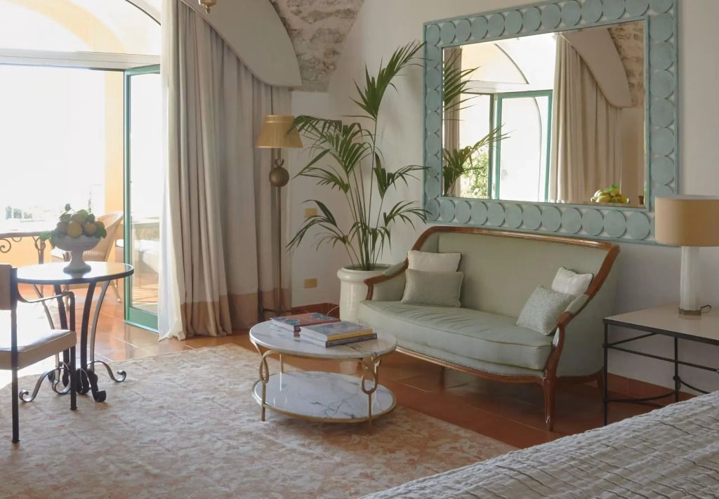 Stilvoller Wohnbereich mit Sofa, großem Spiegel und Pflanzen