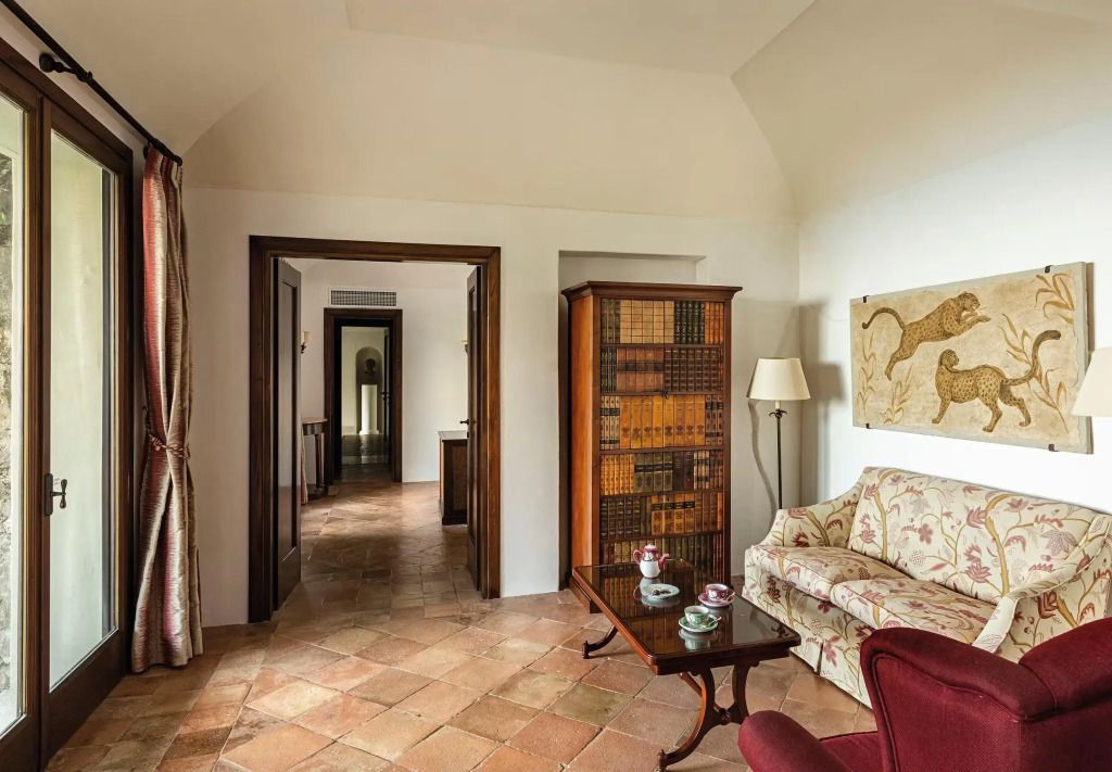 Wohnbereich mit antiker Einrichtung und Bibliothek in der Pompeii Suite