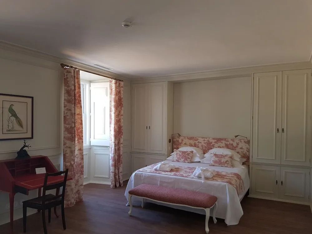 Helles Zimmer mit großem Bett und eleganter Fensterdekoration