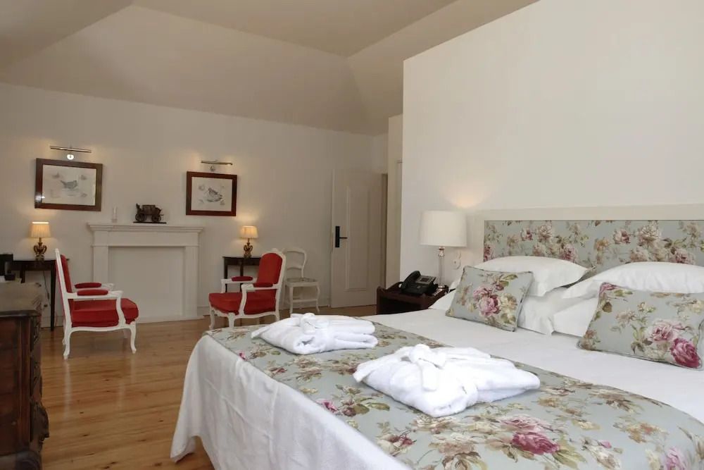 Doppelzimmer mit floraler Bettwäsche und weißen Wänden