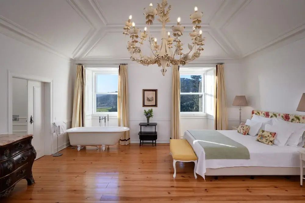 Luxuszimmer mit Kronleuchter und freistehender Badewanne