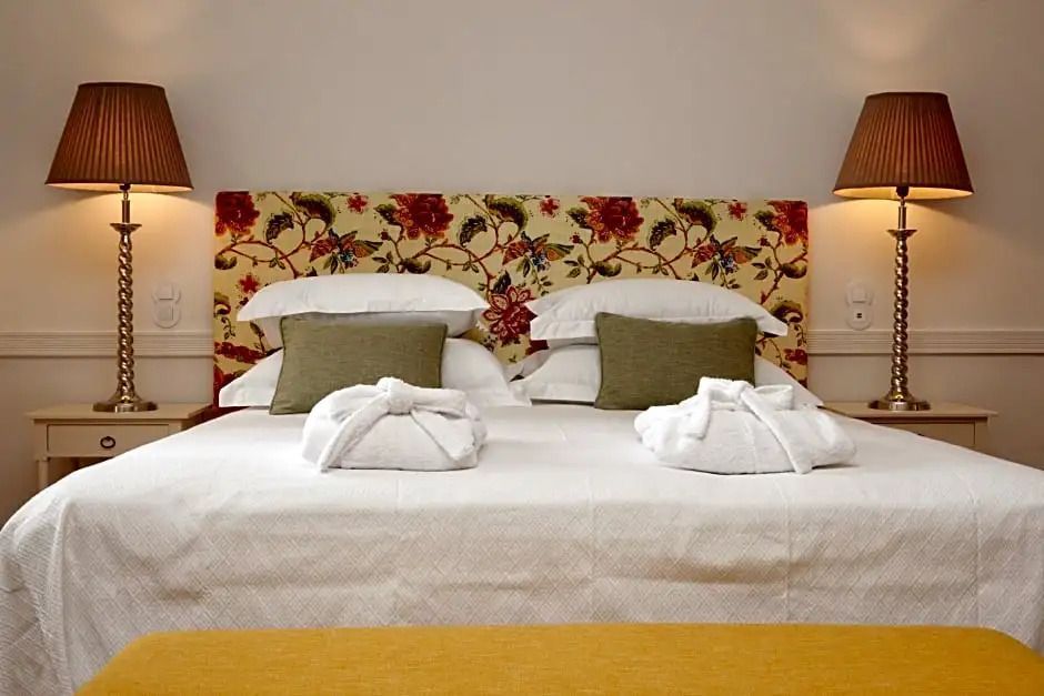Luxuriöses Bett mit dekorativem Kopfteil und sorgfältig arrangierten Kissen